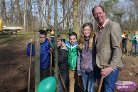 Wethouder Ted Kok plant eerste boom tijdens Boomfeestdag met leerlingen Basisschool 't Warmelinck